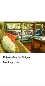 a room with a couch and a book shelf with books at Jardín de Naipí in Puerto Iguazú