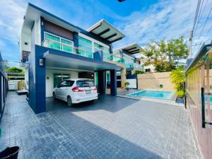 a white car parked in front of a house at KW pool villa pattaya in Pattaya Central
