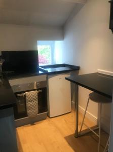a kitchen with a black counter and a table at 1-Bed luxury studio Apartment Cockermouth in Cockermouth