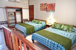 a hotel room with two beds and a balcony at La Quinta Sarapiqui Lodge in Sarapiquí