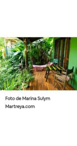a porch with a hammock on a wooden deck at Jardín de Naipí 2 in Puerto Iguazú