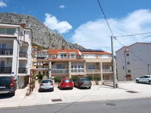 a group of cars parked in a parking lot with a mountain at Apartment Sladojevic in Omiš