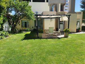 a patio with a table and chairs in a yard at Casa Golfo Nuevo in Puerto Madryn