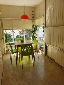 プエルト・マドリンにあるCasa Golfo Nuevoのテーブルと緑の椅子のあるダイニングルーム +9枚の写真