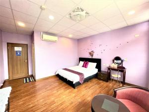 成功的住宿－台東新港民宿，一间卧室配有一张床和紫色的墙壁