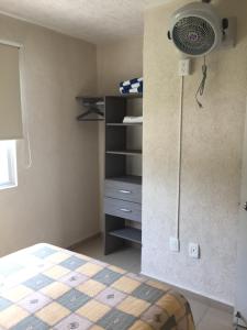 ein Schlafzimmer mit einem Bett und einem Ventilator an der Wand in der Unterkunft Acapulco, Departamento PB en Marina Diamante in Acapulco + 18 Fotos