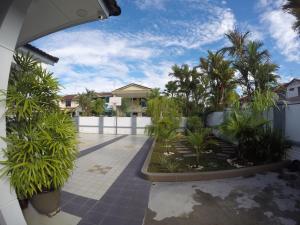 a courtyard with palm trees and a white fence at REBECS 12Pax@TebrauCity/Ikea/Toppen/Aeon in Johor Bahru