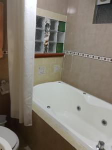 a bathroom with a bath tub and a toilet at Hotel Posada Spa Antigua Casa Hogar in Taxco de Alarcón