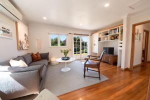 a living room with a couch and a table at The Coastal Casa ~ Close to the beach and town in Mount Maunganui