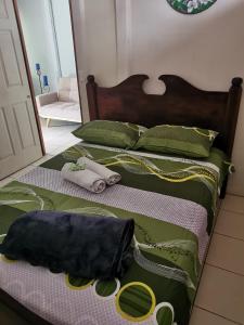a bed with green and white sheets and green and yellow handles at Apartamento D Campos in Heredia