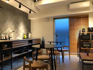 uma cozinha com duas mesas e cadeiras e uma janela em Hotel Asakusa KANNONURA em Tóquio