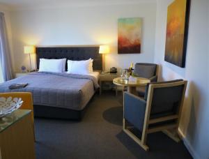 a hotel room with a bed and a table at Park Ridge Retreat in Gerringong +69 photos