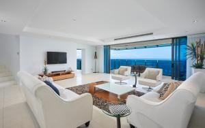 una sala de estar con muebles blancos y vistas al océano. en Soul Surfers Paradise - GCLR, en Gold Coast