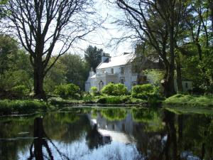 a house that has a pond in front of it at Thrumster House in Wick