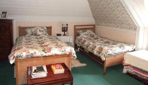 a bedroom with two beds and a table with books at Thrumster House in Wick