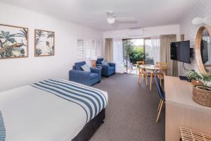 モリーモックにあるMollymook Seascape Motel and Apartmentsのベッドルーム1室(ベッド1台付)、リビングルームが備わります。
