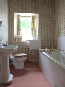 a bathroom with a toilet and a tub and a sink at Thrumster House in Wick
