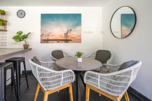 a table and chairs in a room with a mirror at Jagaditha Villas in Sanur