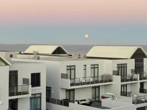 una vista de dos edificios blancos con el océano en el fondo en 209 Azure en Big Bay