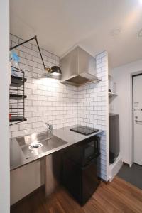 東京にあるStylewood Nishi-Shinjukuのシンクとカウンタートップのあるキッチン