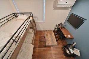 東京にあるStylewood Nishi-Shinjukuのベッドルーム(二段ベッド1組、デスク、テレビ付)