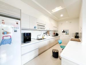 a kitchen with white cabinets and a refrigerator at Corner No50 Hostel in Taitung City