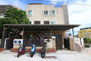 two motorcycles parked in front of a building at Corner No50 Hostel in Taitung City