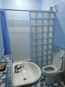 a bathroom with a sink and a toilet at Ravenala Beach Bungalows in Moalboal