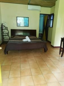 a bed in a room with a tiled floor at Ravenala Beach Bungalows in Moalboal