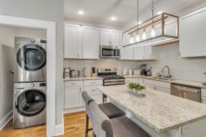 a kitchen with white cabinets and a washer and dryer at Recently Renovated Home in the Heart of Bellevue! home in Bellevue