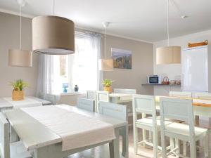 a dining room with a white table and chairs at Åsbergbo Vandrarhem in Vallsta