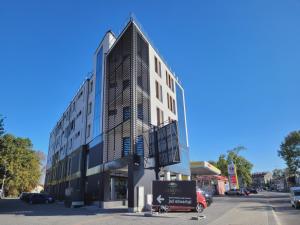 wysoki biały budynek ze spiczastym dachem na ulicy w obiekcie Hotel Sanova w mieście Jarosław