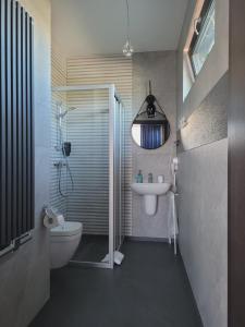 een badkamer met een wastafel, een toilet en een douche bij Hotel Sanova in Jarosław