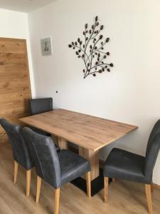 een eettafel en stoelen met een houten tafel bij Appartement Melanie in Wagrain +11 foto's