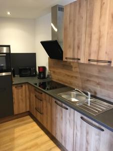 uma cozinha com armários de madeira e um lavatório em Appartement Melanie em Wagrain