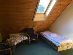 a attic room with a bed and a chair and a window at U poľovníka in Levoča