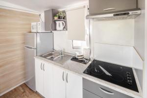 a small kitchen with a sink and a refrigerator at Waterman Beach Village in Supetar