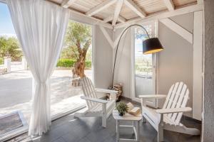 a room with two white chairs and a window at Waterman Beach Village in Supetar