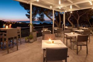 un restaurante con mesas y sillas en un patio por la noche en Waterman Beach Village, en Supetar