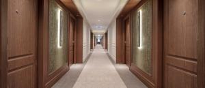 un couloir dans un bâtiment avec des portes en bois et un couloir dans l'établissement InterContinental Athenee Palace Bucharest, an IHG Hotel, à Bucarest