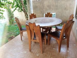 una mesa de madera y sillas en una habitación en Villa ETE-D, en Bohicon