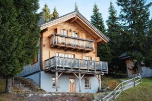 a large wooden house with a balcony on it at Holiday village Koralpe St- Stefan im Lavanttal - OKT07003-FYC in Elsenbrunn