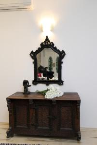 a mirror on top of a table with flowers on it at Apartment Papalić Palace in Split