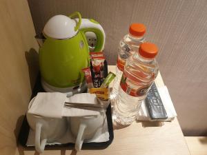 a counter with a tea pot and two bottles of water at Hotel Lereng Bromo in Pasuruan