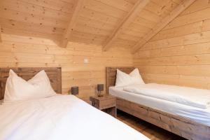 twee bedden in een kamer met houten wanden bij Holiday village Koralpe St- Stefan im Lavanttal - OKT07003-FYD in Elsenbrunn