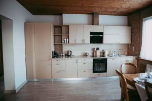 a kitchen with white cabinets and a table in a room at RUMIDO Suite in Valmiera