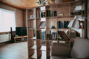 a book shelf filled with books in a living room at RUMIDO Suite in Valmiera