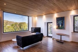 a living room with a couch and a large window at Chez Mimi - La Petite Maison in Raulhac