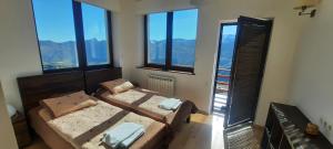 Zimmer mit 2 Betten in einem Zimmer mit Fenstern in der Unterkunft Chalet Marina Gudauri in Gudauri