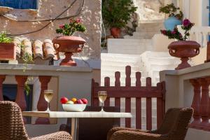 a table with a bowl of fruit and two glasses of wine at 7 Brothers Hotel in Poros